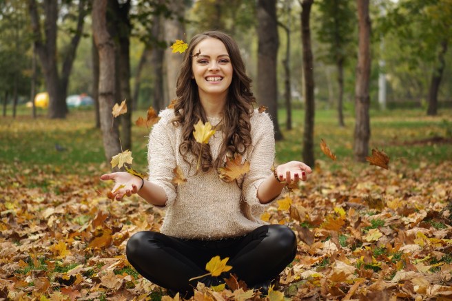 woman-tossing-leaves-in-yoga-pose